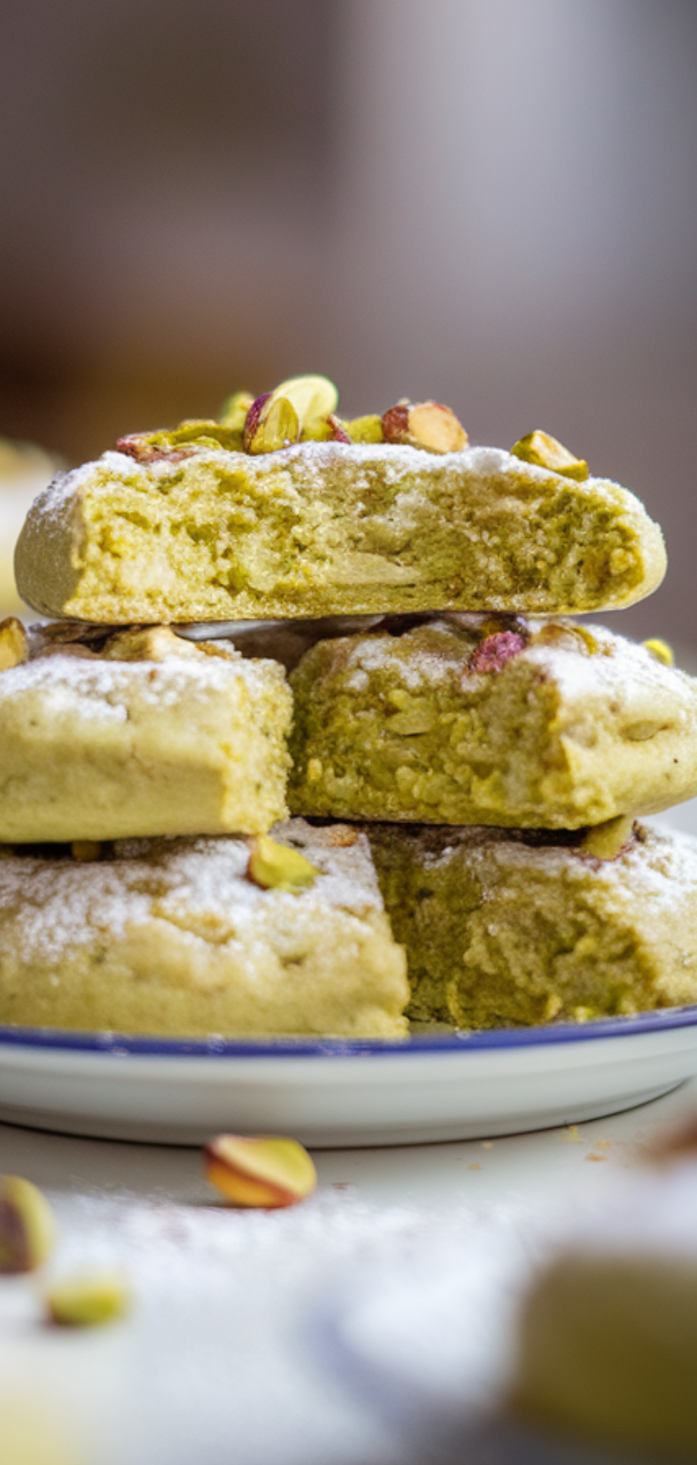 "Freshly baked pistachio pudding cookies with chopped pistachios, styled on a bright white table."