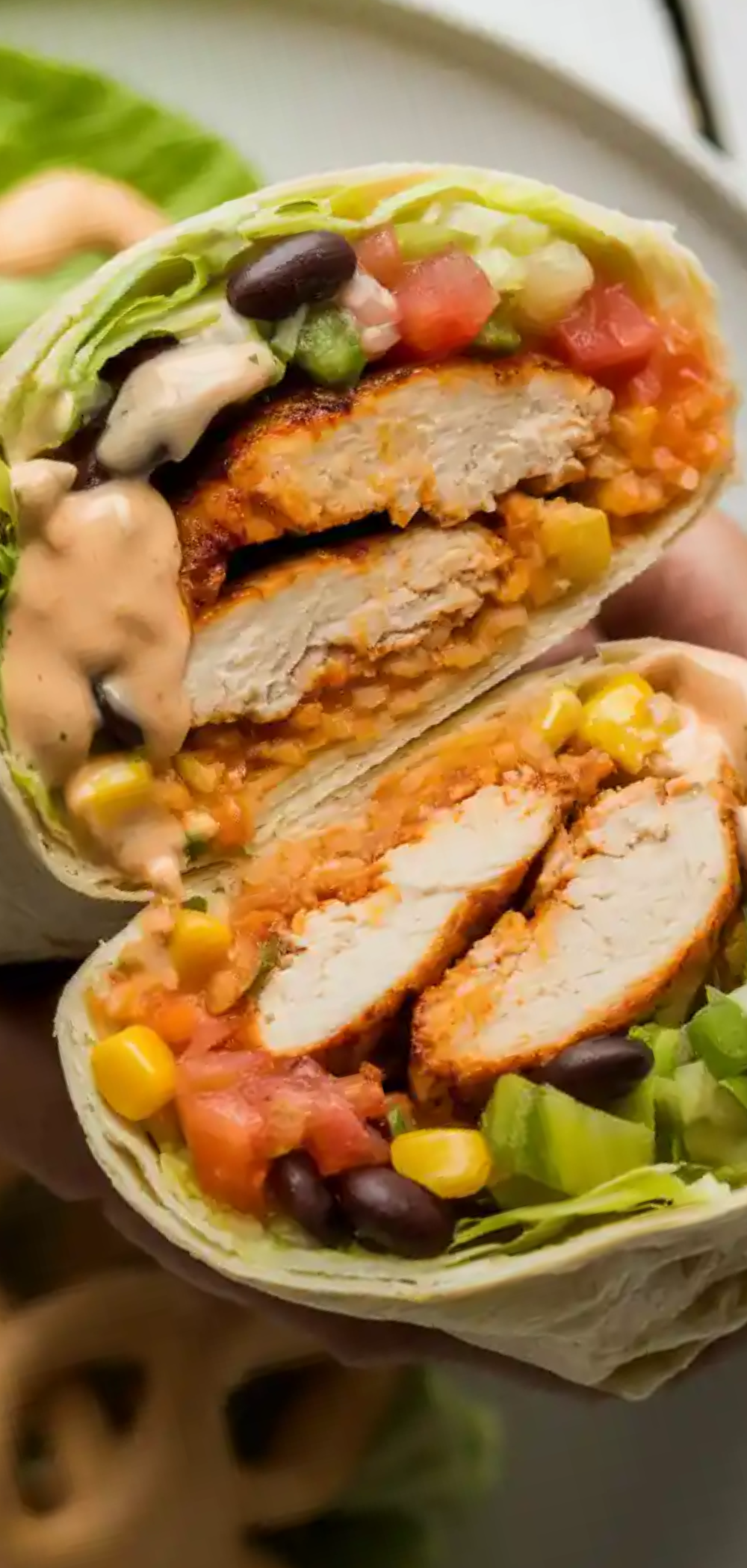 “Juicy grilled chicken strips inside a flour tortilla with cheddar cheese, lettuce, and black beans, drizzled with smoky chipotle ranch sauce, photographed like a professional food blog.”