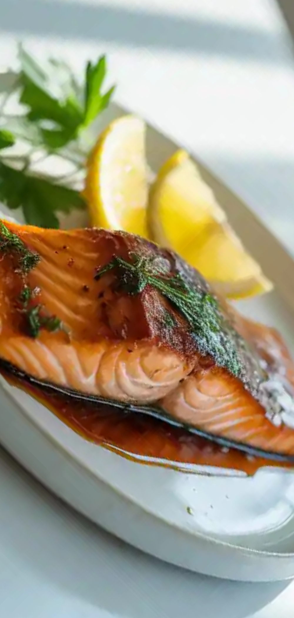 “Oven baked salmon glazed with maple syrup and bourbon, garnished with herbs, styled on a clean white table for food photography.”
