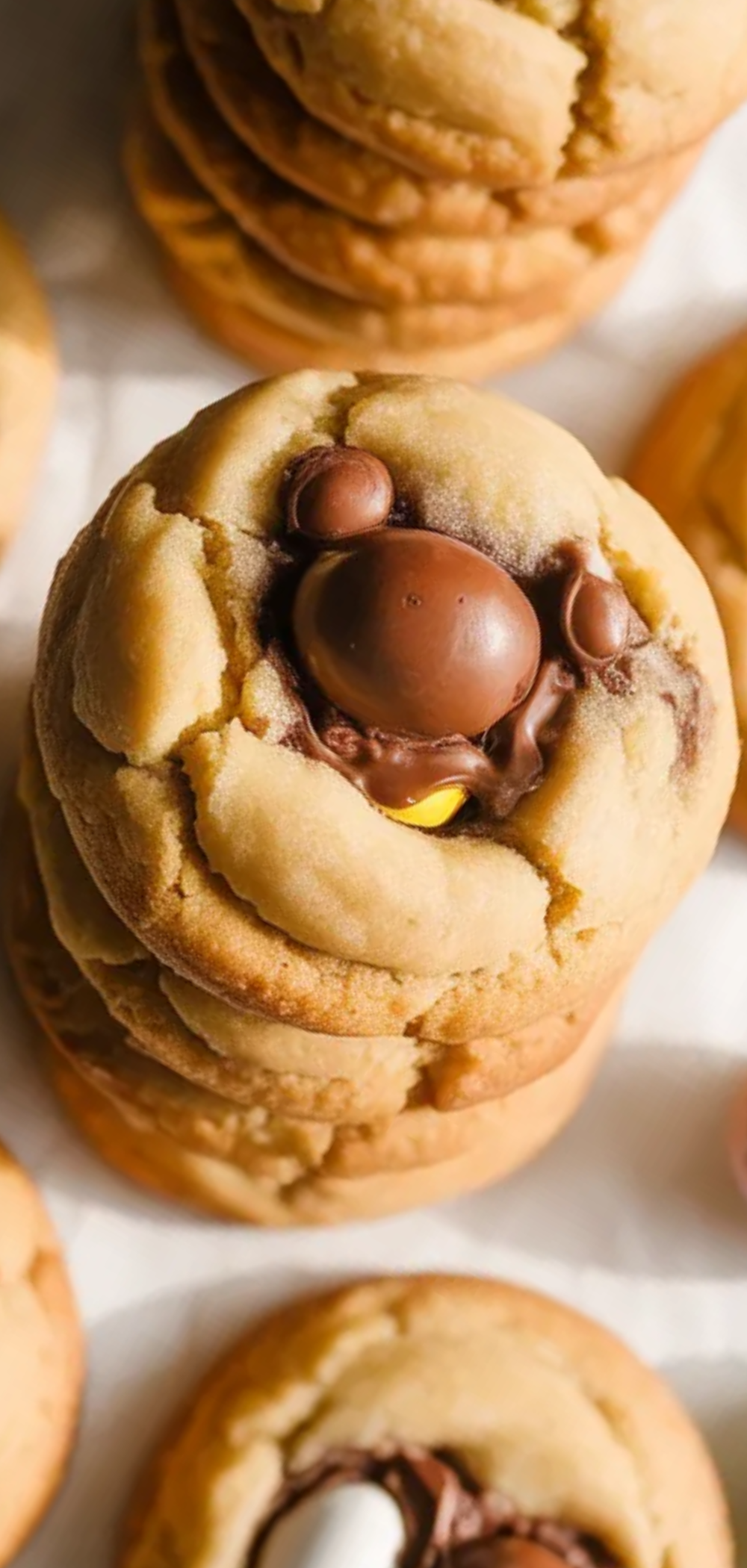 Close-up of golden brown cookies with melted Cadbury mini eggs inside, arranged casually on a white plate, warm and inviting homemade look