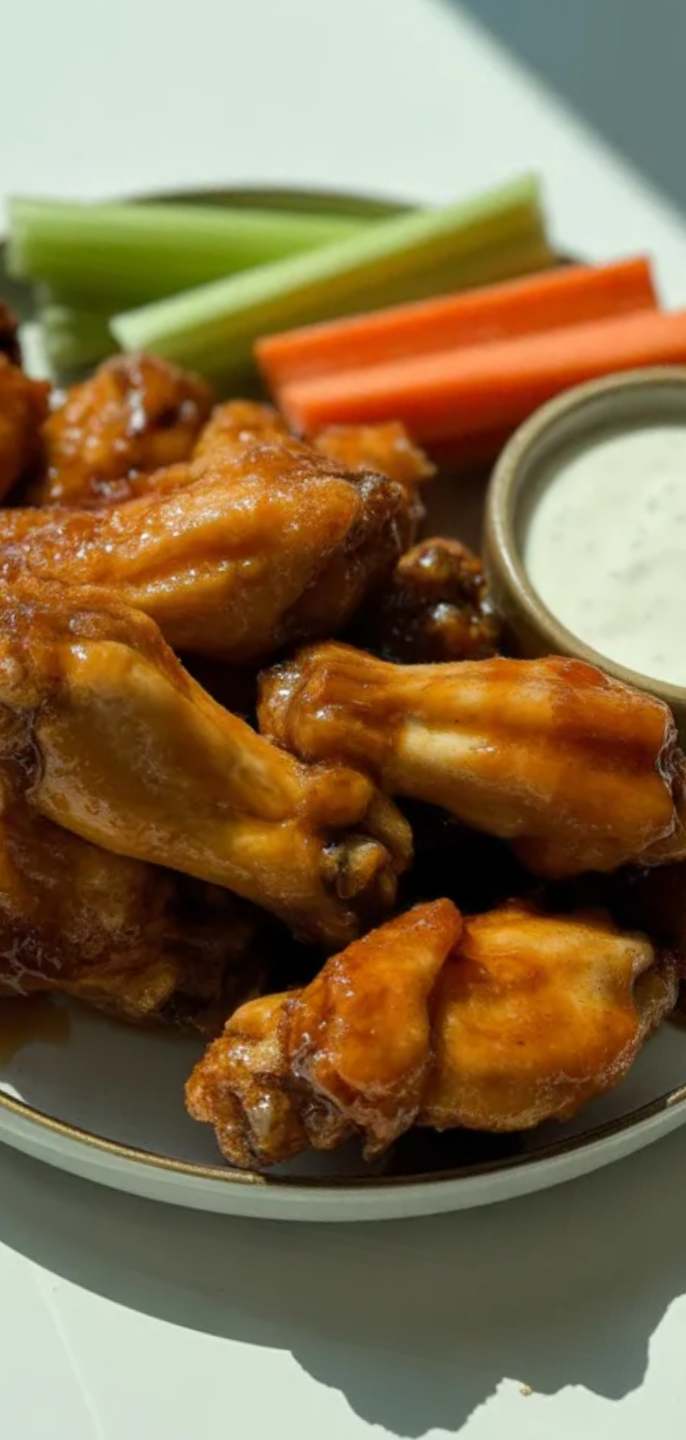 “Oven-baked Hot Honey Wings coated in sticky honey and chili sauce, served on a white plate with a clean background.”