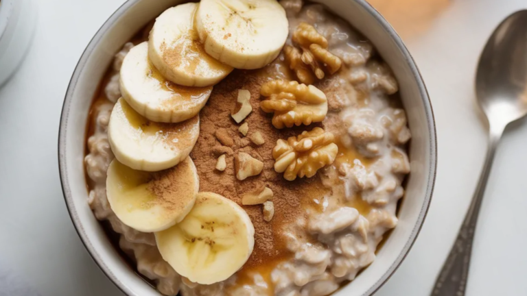 “Bowl of creamy Healthy Cinnamon Roll Overnight Oats No Yogurt topped with sliced bananas, walnuts, and a sprinkle of cinnamon on a white table with soft natural lighting”