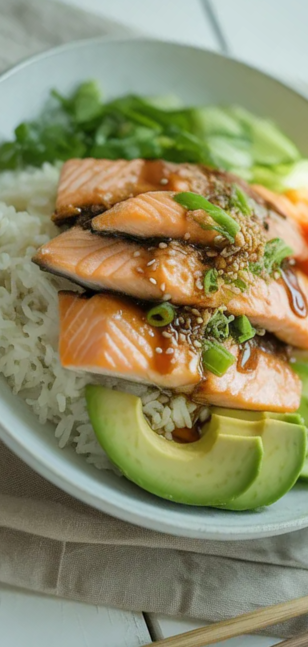 Healthy salmon rice bowl served on a white table featuring fresh salmon, rice, avocado, cucumber, and sesame toppings in a clean food blog style presentation