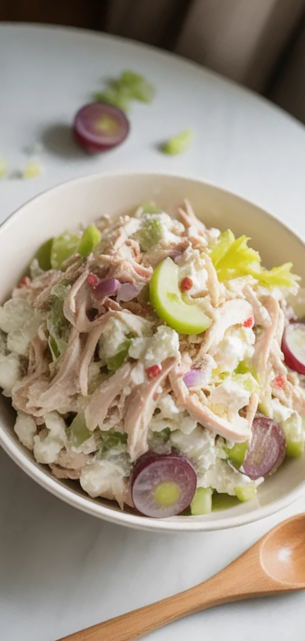 Healthy high-protein chicken salad made with cottage cheese, fresh vegetables, and grapes served in a clean white bowl with minimal food styling