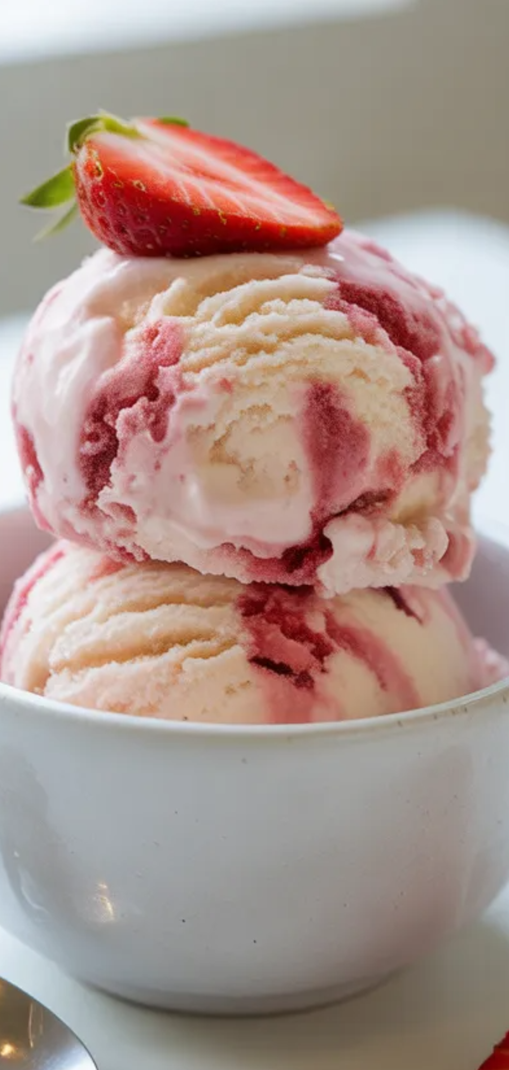 Healthy strawberry cottage cheese ice cream served in a white dish with fresh strawberries on top, minimal food styling and bright natural light