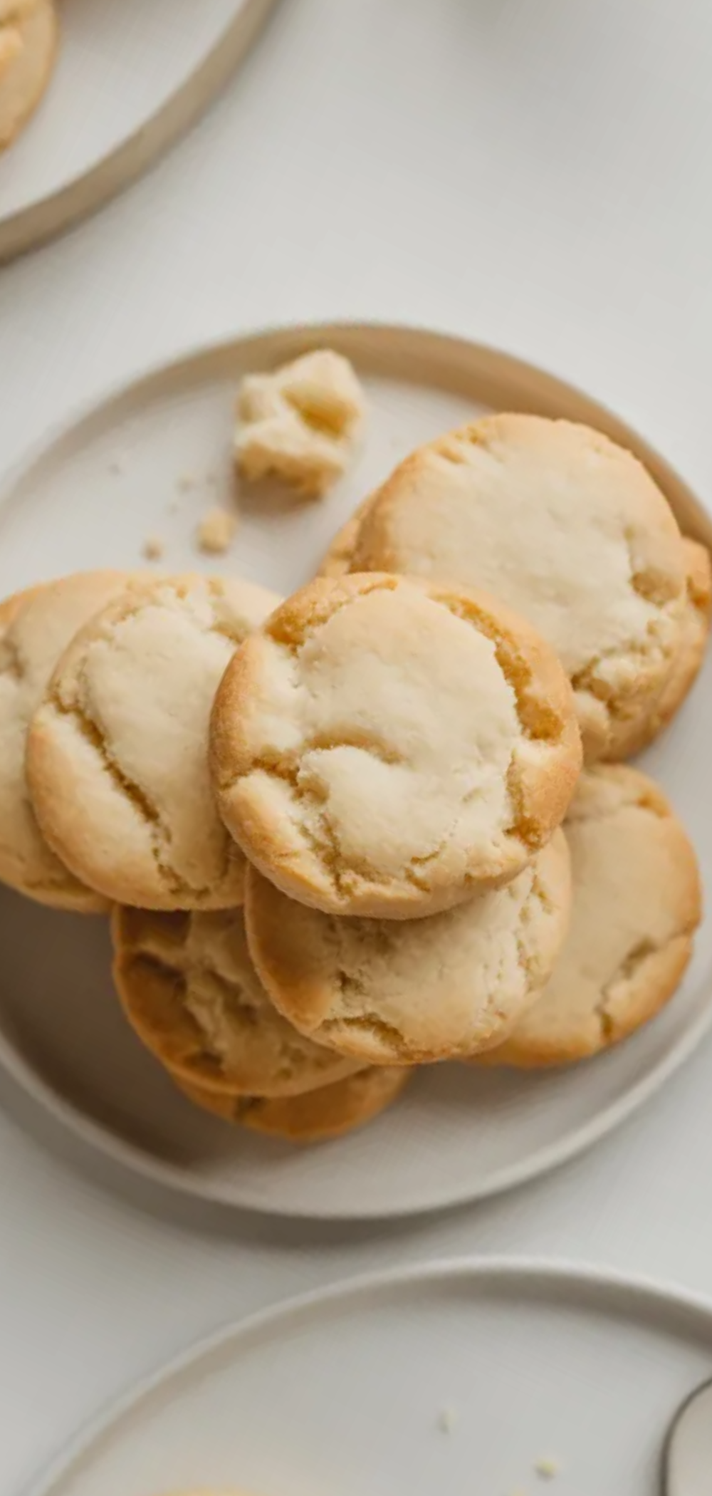 Easy 3-ingredient butter cookies stacked on a white ceramic plate, minimalist food styling, soft and golden texture.