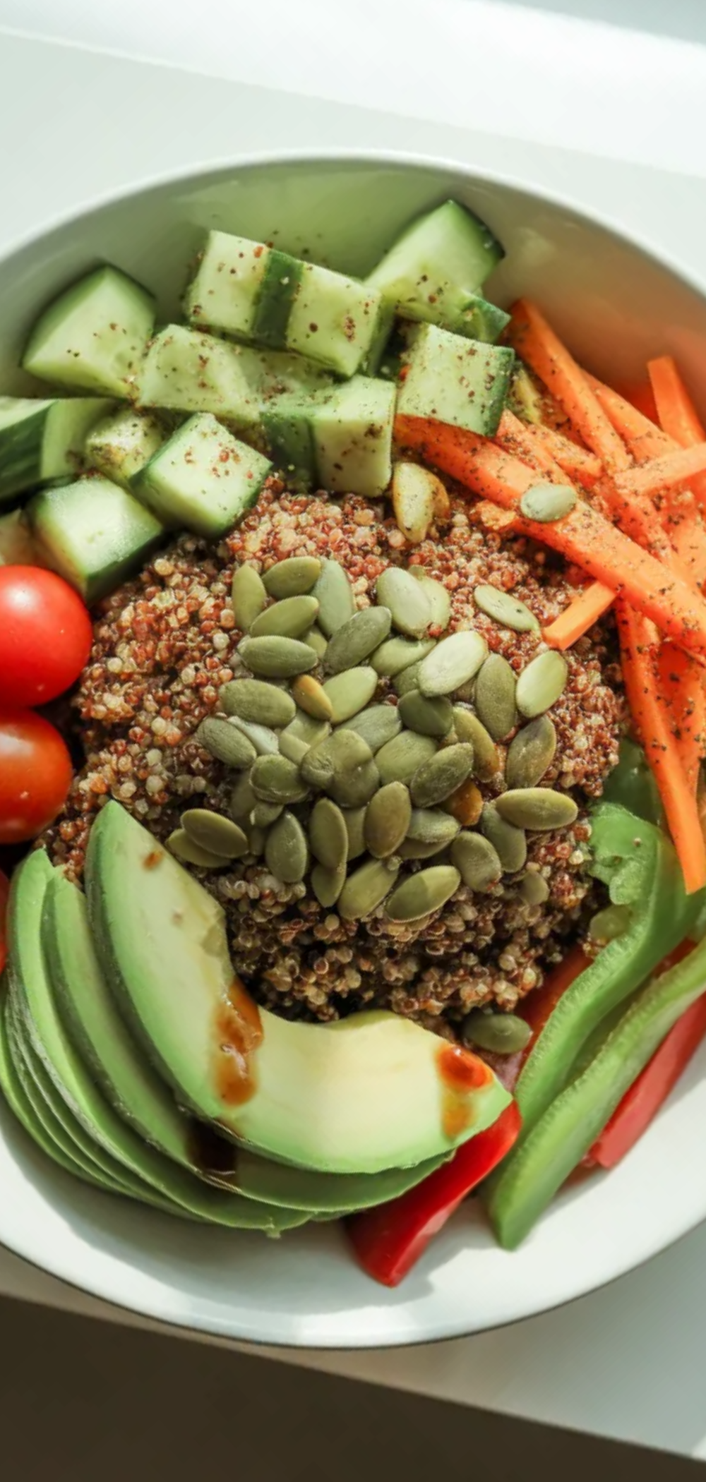 “Healthy quinoa bowl under 500 calories, fresh vegetables and light dressing, served in a white ceramic bowl, top-down view with natural lighting”