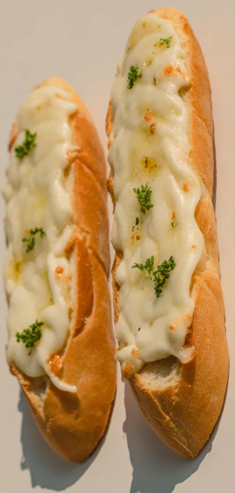Easy 5 ingredient cheesy garlic bread sliced and served on a clean white background