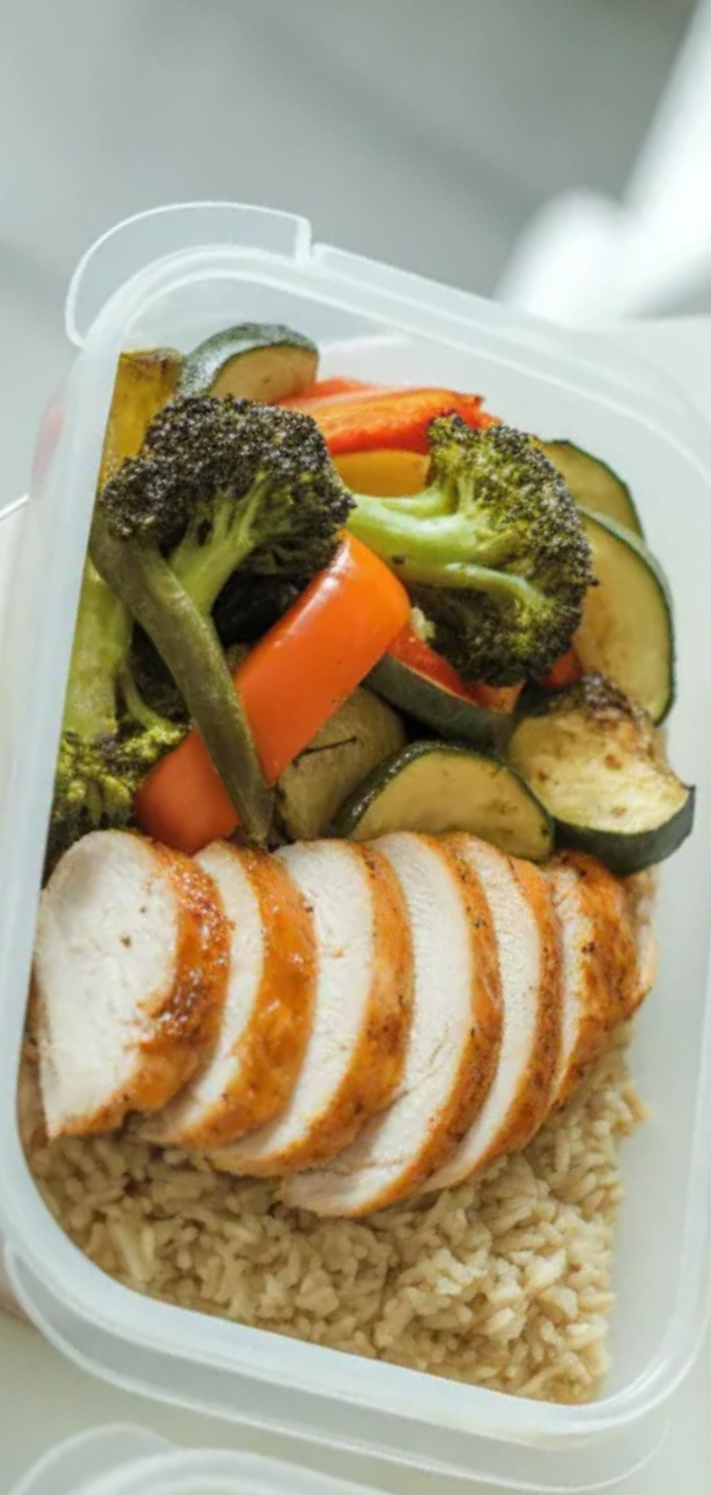 Easy healthy chicken meal prep bowls with broccoli, bell peppers, zucchini, and rice, arranged in meal prep containers with minimal shadows
