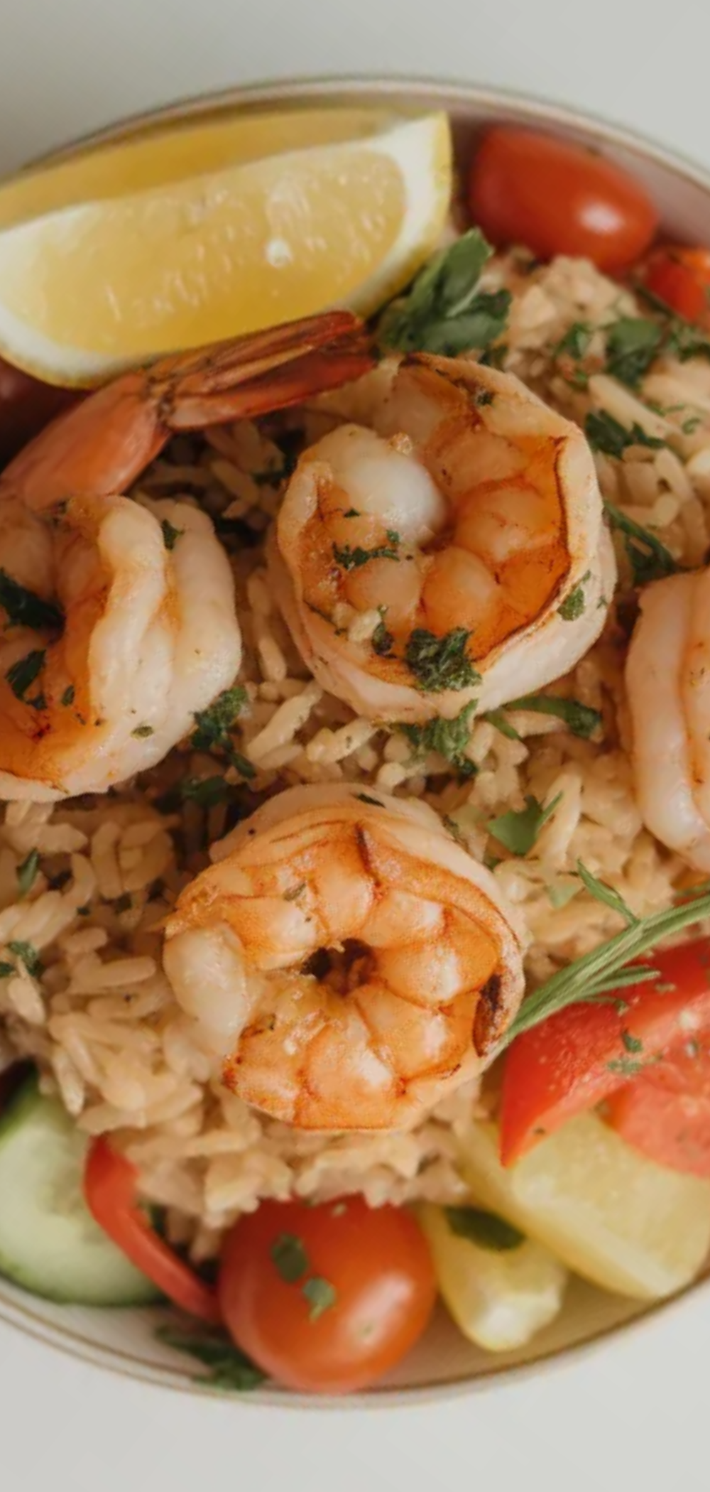 Healthy lemon shrimp rice bowl with vibrant veggies and fresh herbs, styled like a food blogger photo.