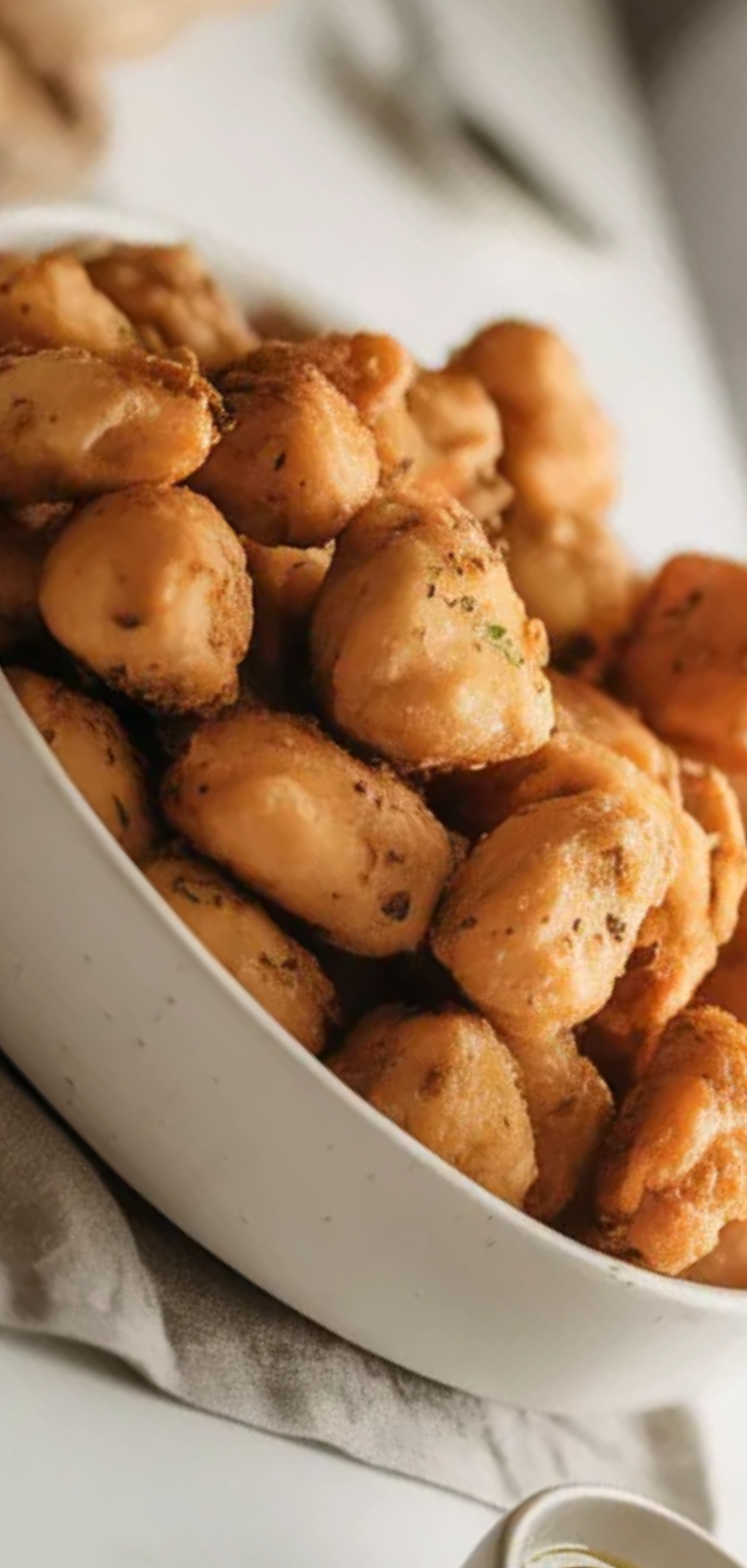 Juicy and crispy chicken bites made in the air fryer styled on a white table with a simple food blogger aesthetic