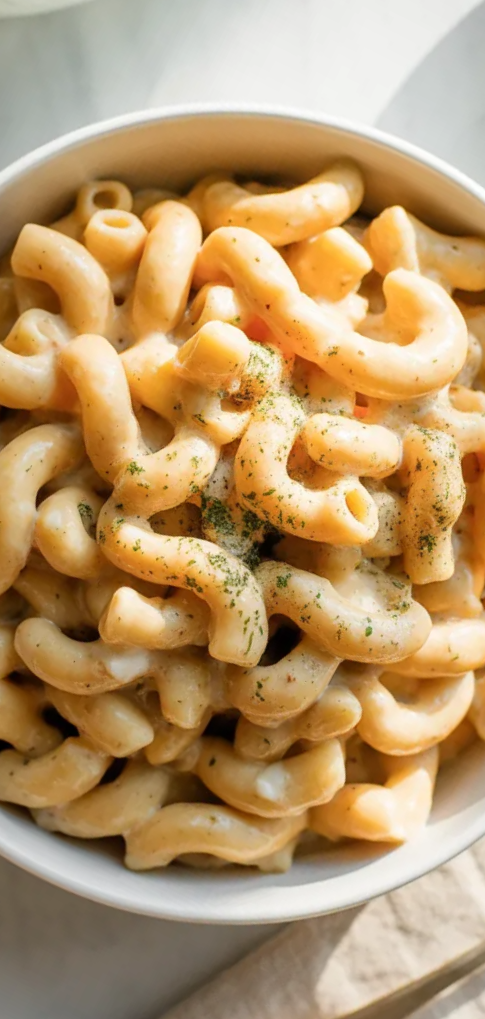 Light and creamy mac and cheese with blended veggie sauce on a bright white background

