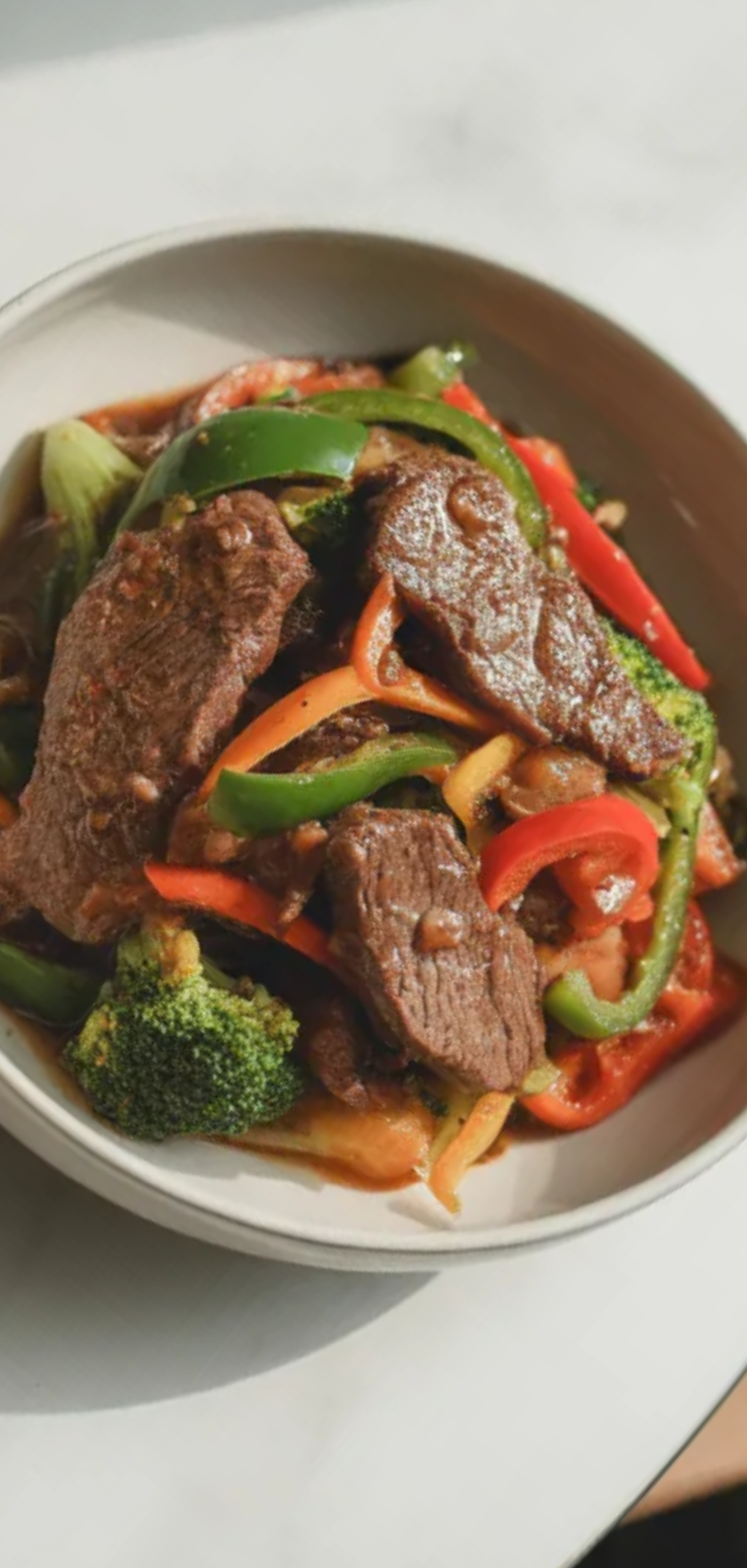 Easy healthy beef stir fry recipe with fresh vegetables and juicy beef served in a white bowl, quick 30-minute homemade dinner on a bright white background