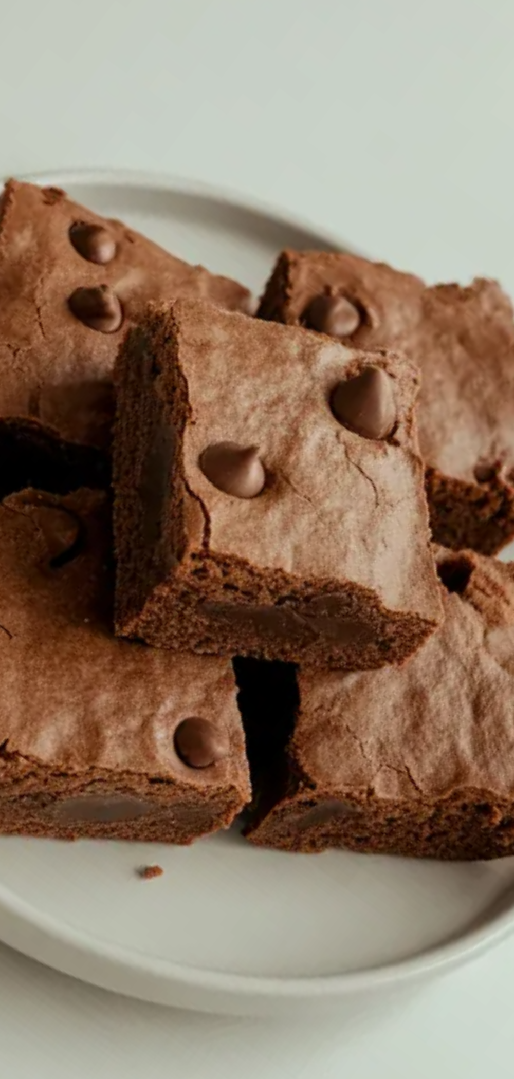 Easy high protein brownies arranged neatly on a white plate with a simple clean food photography style